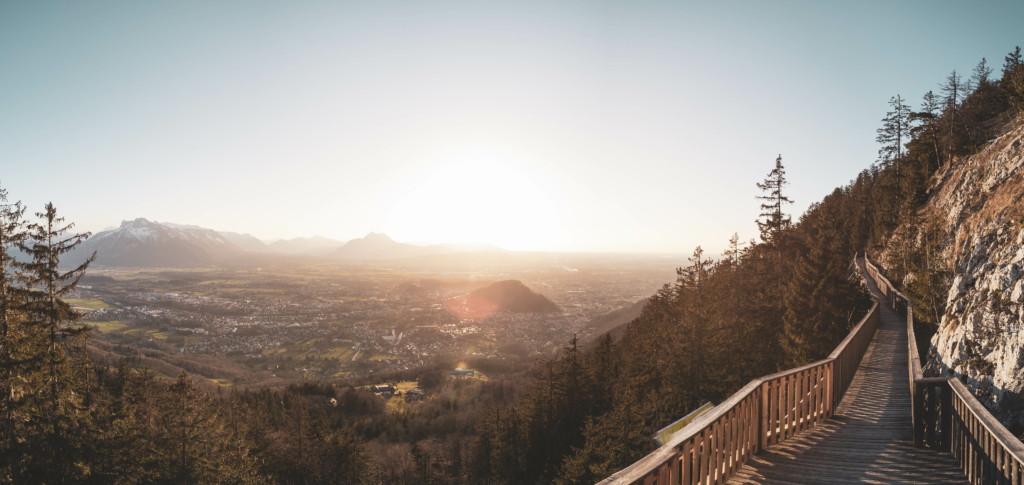 Spaziergang, Wanderung und Ausblicke auf die Mozartstadt Salzburg vom Sendlwand-Steg auf der Südseite des Salzburger Gaisberg zu Sonnenuntergang im Frühling, Salzburg, Österreich.