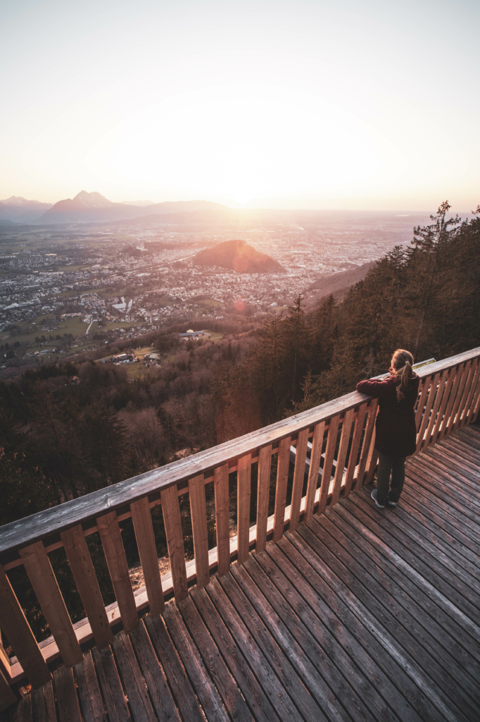 Spaziergang, Wanderung und Ausblicke auf die Mozartstadt Salzburg vom Sendlwand-Steg auf der Südseite des Salzburger Gaisberg zu Sonnenuntergang im Frühling, Salzburg, Österreich.