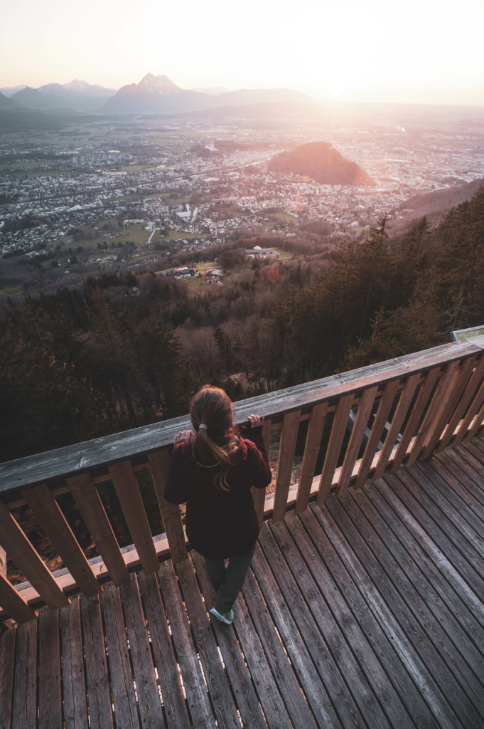 Spaziergang, Wanderung und Ausblicke auf die Mozartstadt Salzburg vom Sendlwand-Steg auf der Südseite des Salzburger Gaisberg zu Sonnenuntergang im Frühling, Salzburg, Österreich.