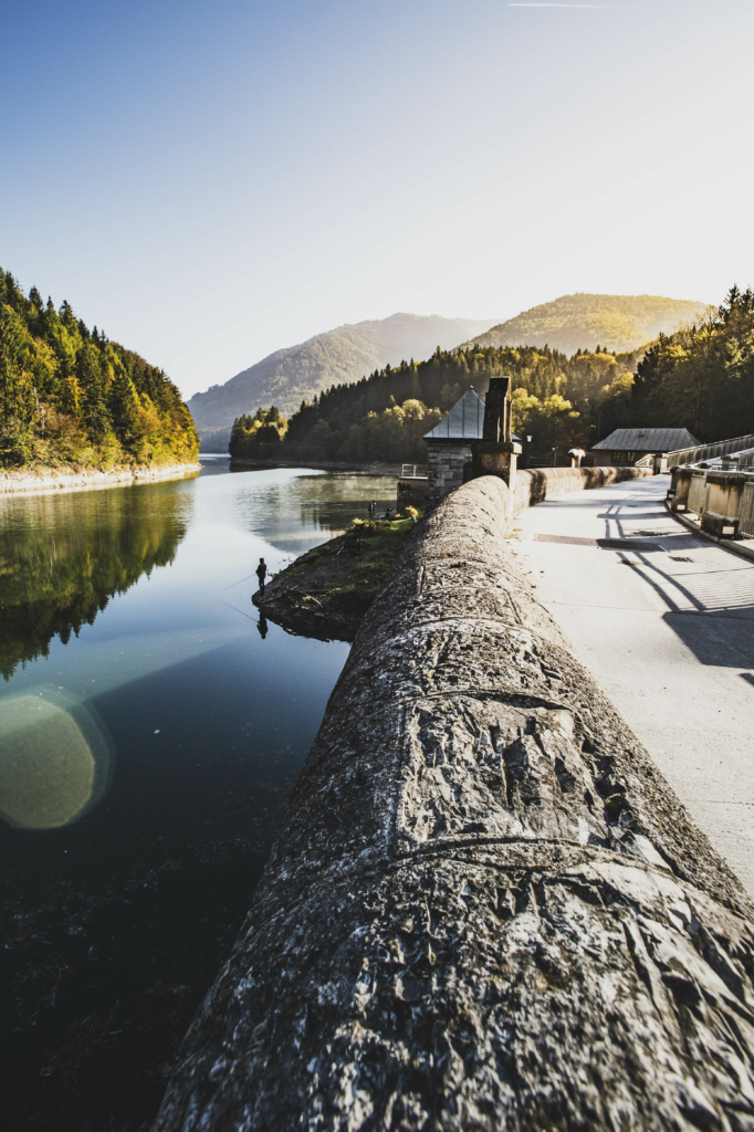 Am Staudamm des Wiestalerstausee bei Sonnenaufgang im Herbst im Salzburger Land, Österreich.