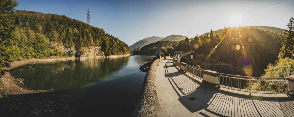 Am Staudamm des Wiestalerstausee bei Sonnenaufgang im Herbst im Salzburger Land, Österreich.