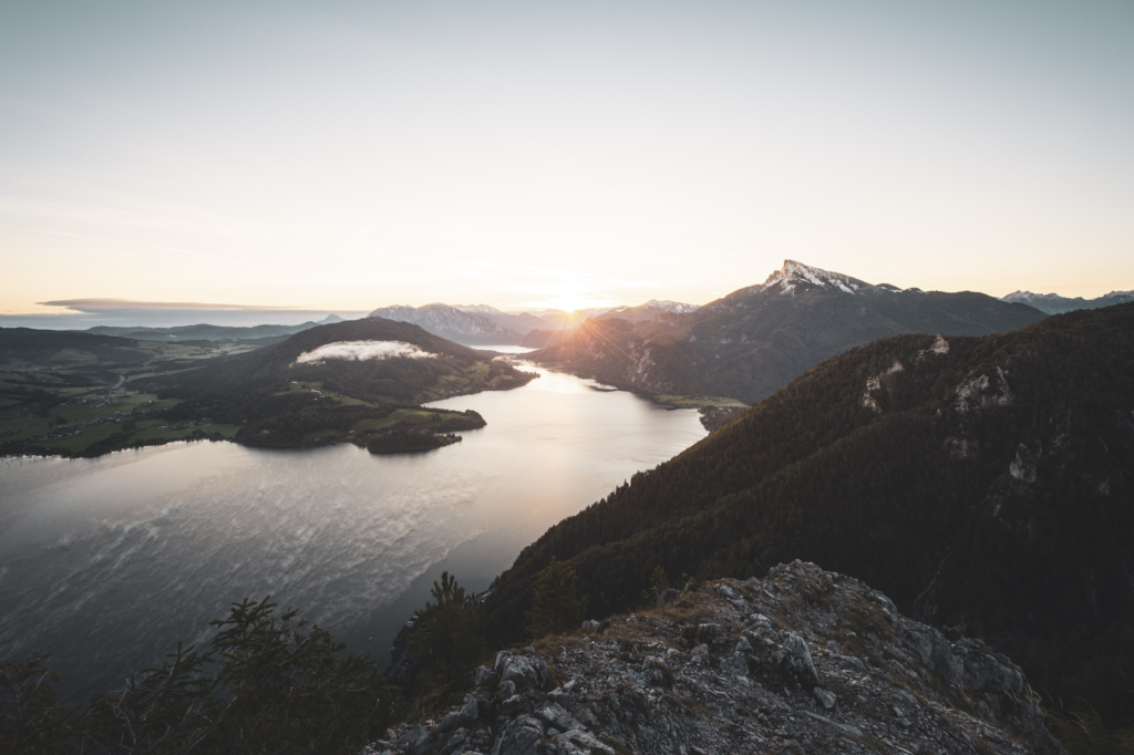 Sonnenaufgang am Gipfel der Drachenwand und Blick auf den Mondsee. Mit einer Höhe von 1176 hm liegt sie in den Salzkammergut-Bergen, einer Berggruppe in den Nördlichen Kalkalpen in Salzburg an der Grenze zu Öberösterreich, Österreich.