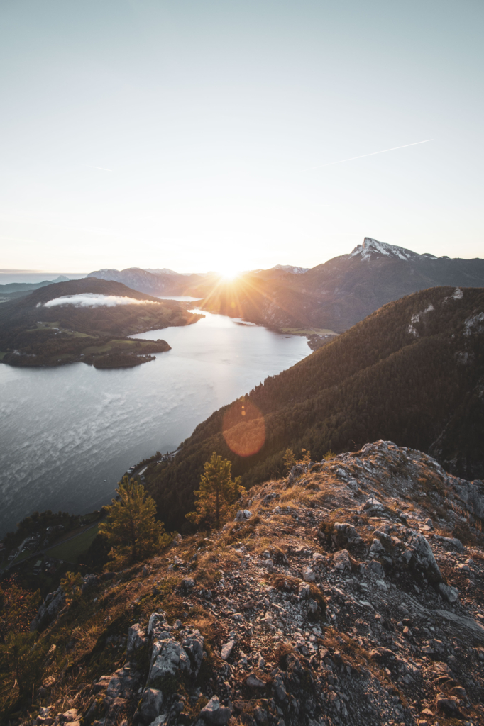 Sonnenaufgang am Gipfel der Drachenwand und Blick auf den Mondsee. Mit einer Höhe von 1176 hm liegt sie in den Salzkammergut-Bergen, einer Berggruppe in den Nördlichen Kalkalpen in Salzburg an der Grenze zu Öberösterreich, Österreich.