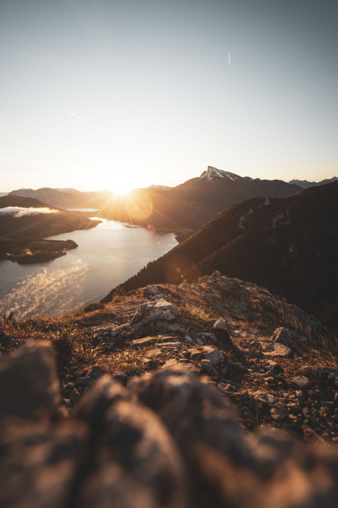 Sonnenaufgang am Gipfel der Drachenwand und Blick auf den Mondsee. Mit einer Höhe von 1176 hm liegt sie in den Salzkammergut-Bergen, einer Berggruppe in den Nördlichen Kalkalpen in Salzburg an der Grenze zu Öberösterreich, Österreich.