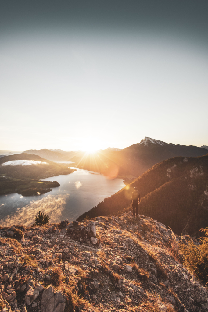 Sonnenaufgang am Gipfel der Drachenwand und Blick auf den Mondsee. Mit einer Höhe von 1176 hm liegt sie in den Salzkammergut-Bergen, einer Berggruppe in den Nördlichen Kalkalpen in Salzburg an der Grenze zu Öberösterreich, Österreich.