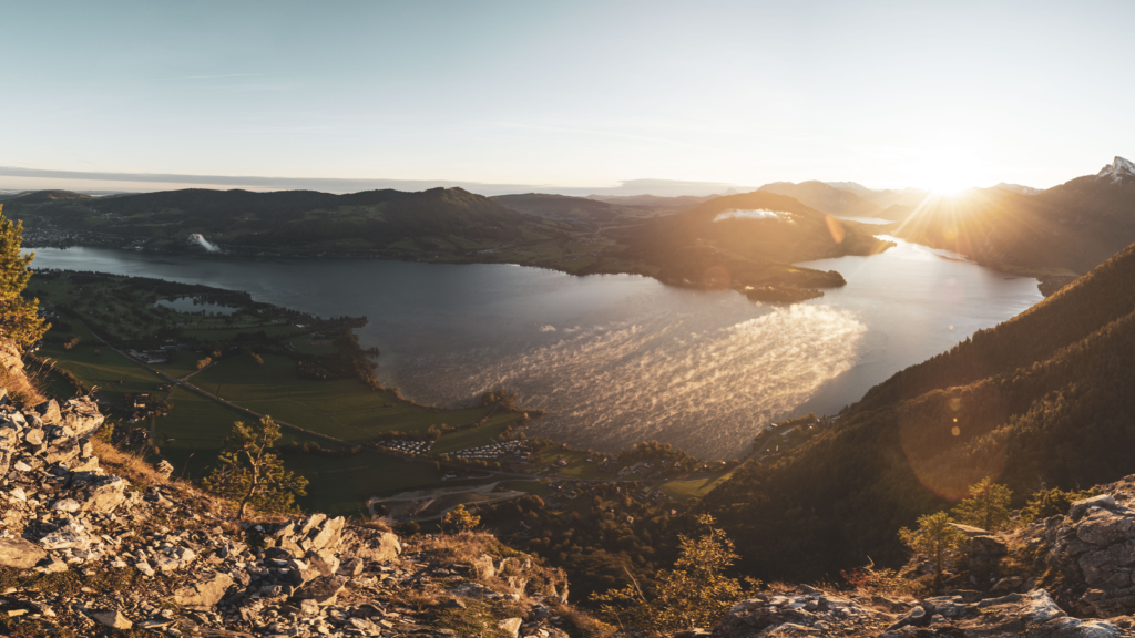 Sonnenaufgang am Gipfel der Drachenwand und Blick auf den Mondsee. Mit einer Höhe von 1176 hm liegt sie in den Salzkammergut-Bergen, einer Berggruppe in den Nördlichen Kalkalpen in Salzburg an der Grenze zu Öberösterreich, Österreich.