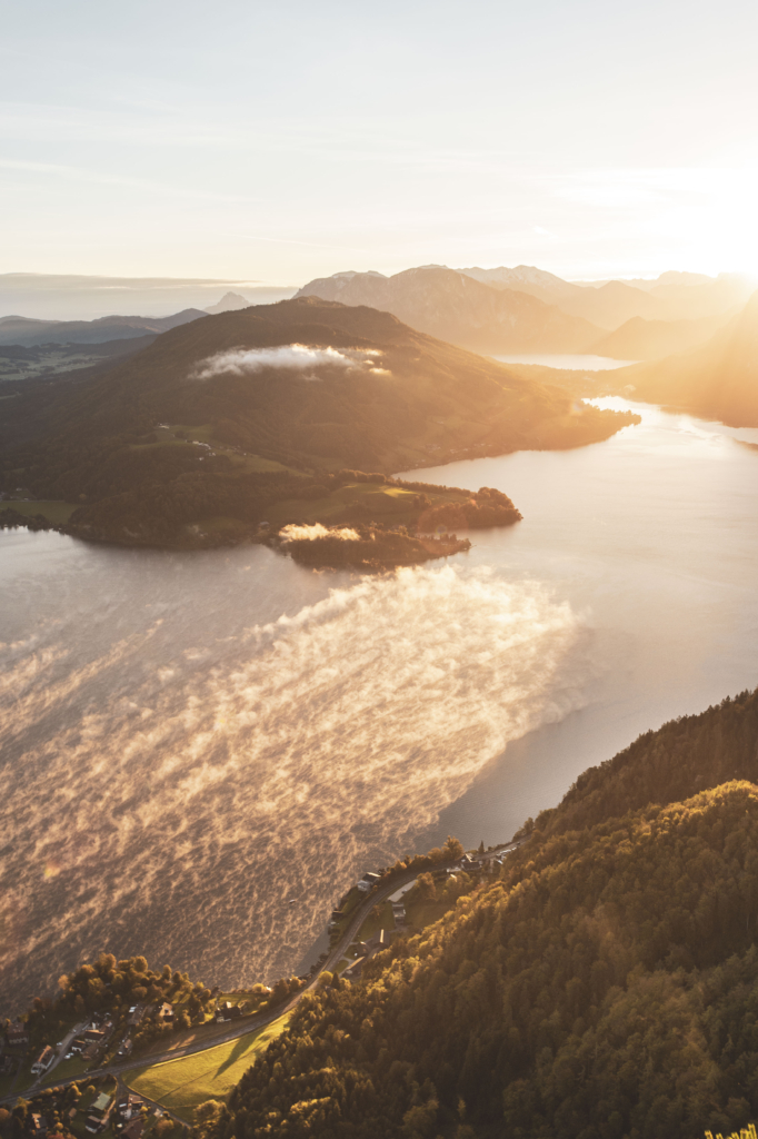 Sonnenaufgang am Gipfel der Drachenwand und Blick auf den Mondsee. Mit einer Höhe von 1176 hm liegt sie in den Salzkammergut-Bergen, einer Berggruppe in den Nördlichen Kalkalpen in Salzburg an der Grenze zu Öberösterreich, Österreich.