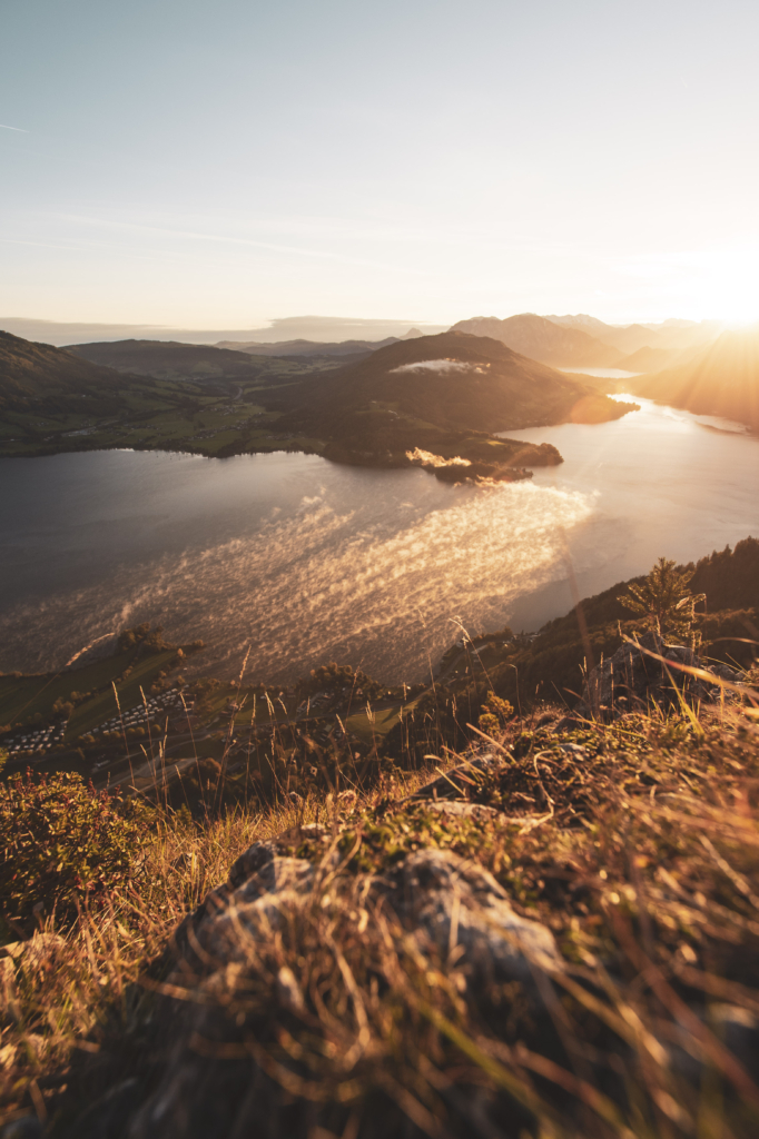 Sonnenaufgang am Gipfel der Drachenwand und Blick auf den Mondsee. Mit einer Höhe von 1176 hm liegt sie in den Salzkammergut-Bergen, einer Berggruppe in den Nördlichen Kalkalpen in Salzburg an der Grenze zu Öberösterreich, Österreich.