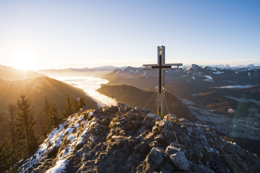 Gipfelkreuz des Frauenkopfes und Blick in die Salzkammergut-Berge bei Sonnenaufgang.