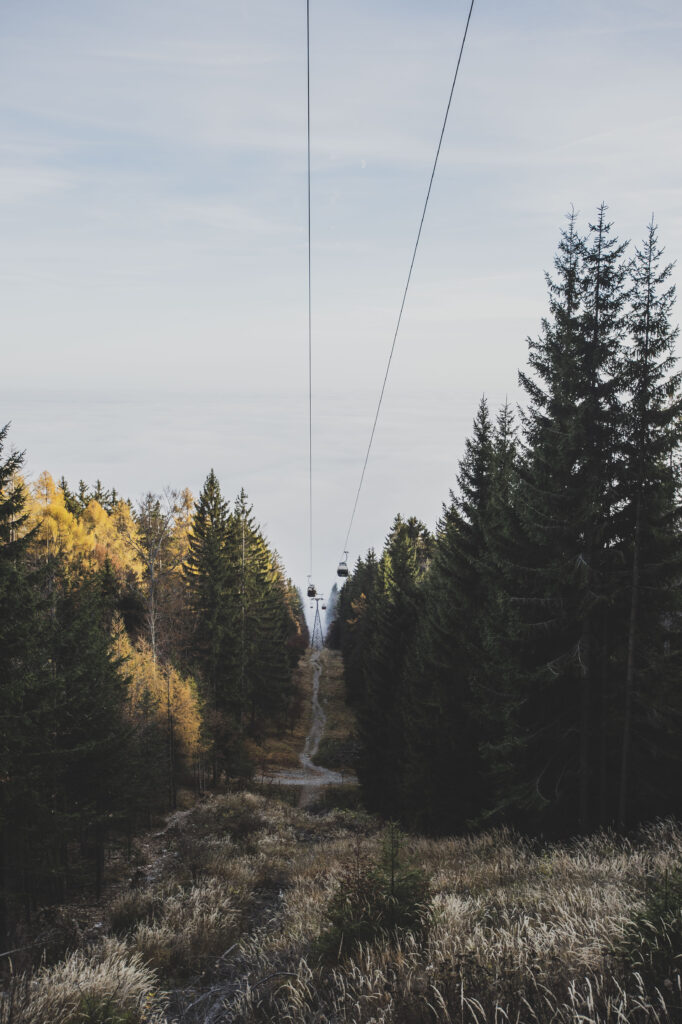 Die Gondeln der Schöckl-Seilbahn bahnen sich ihren Weg durch den herbstlichen Nebel in der Steiermark, Österreich.