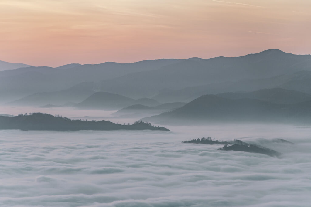 Nebeldecke über dem Grazer Bergland. Sonneuntergang am Gipfel des Grazer Hausberges Schöckl im Herbst, in der Steiermark, Österreich.