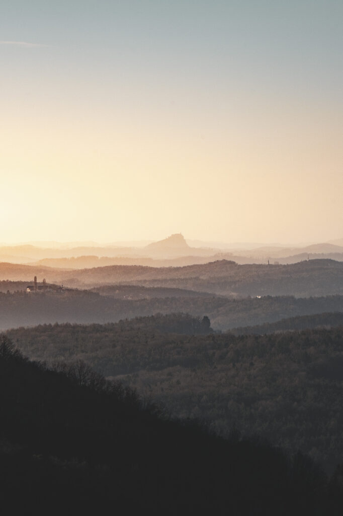 Sonnenaufgang beim Schloss Herberstein mit Blick auf die Riegersburg am Horizont