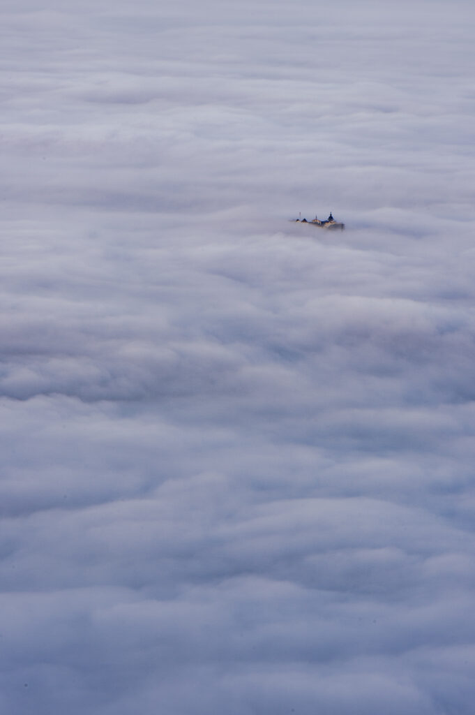 Die Festung Hohensalzburg ragt aus dem Morgennebel. Fotografiert vom Gaisberg, Salzburg Land, Österreich.