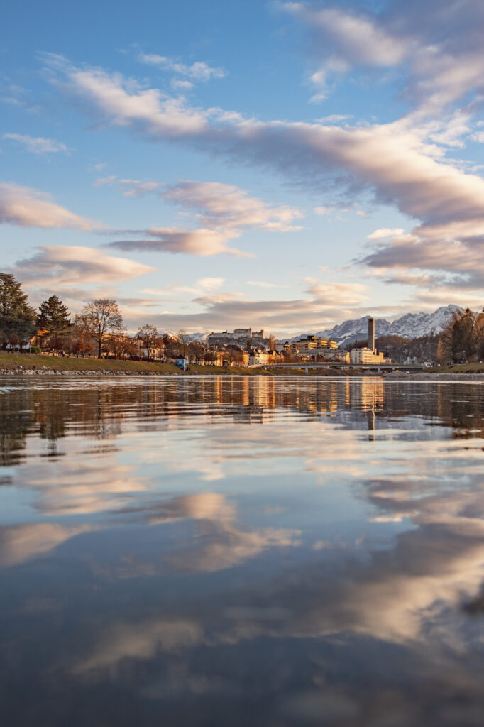 Sonnenuntergang und Blick über die Salzach und die Altstadt Salzburg mit der Festung Hohensalzburg im Hintergrund in Österreich.