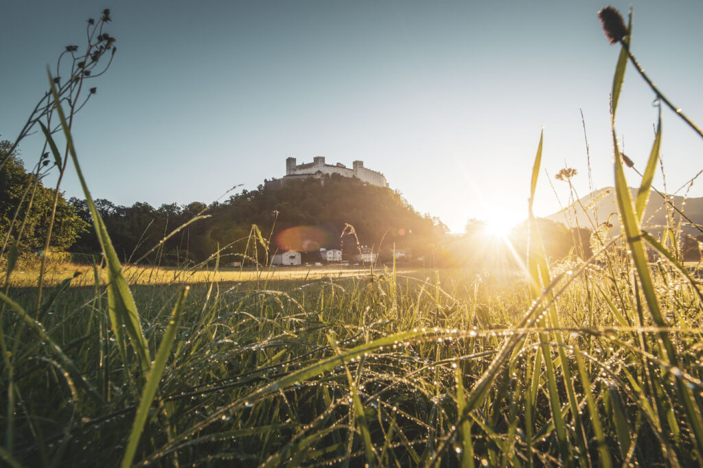 Sonnenaufgang neben dem Mönchsberg und der Festung Hohensalzburg in der Mozartstadt Salzburg, im Salzburger Land, Österreich.